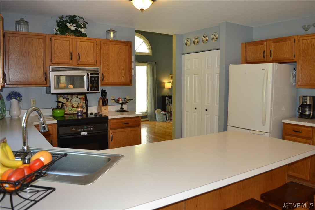 15012 Walnut Bend Road Midlothian, VA 23112 - Photo 6 of 27 a kitchen with a refrigerator a stove top oven a sink dishwasher and wooden cabinets