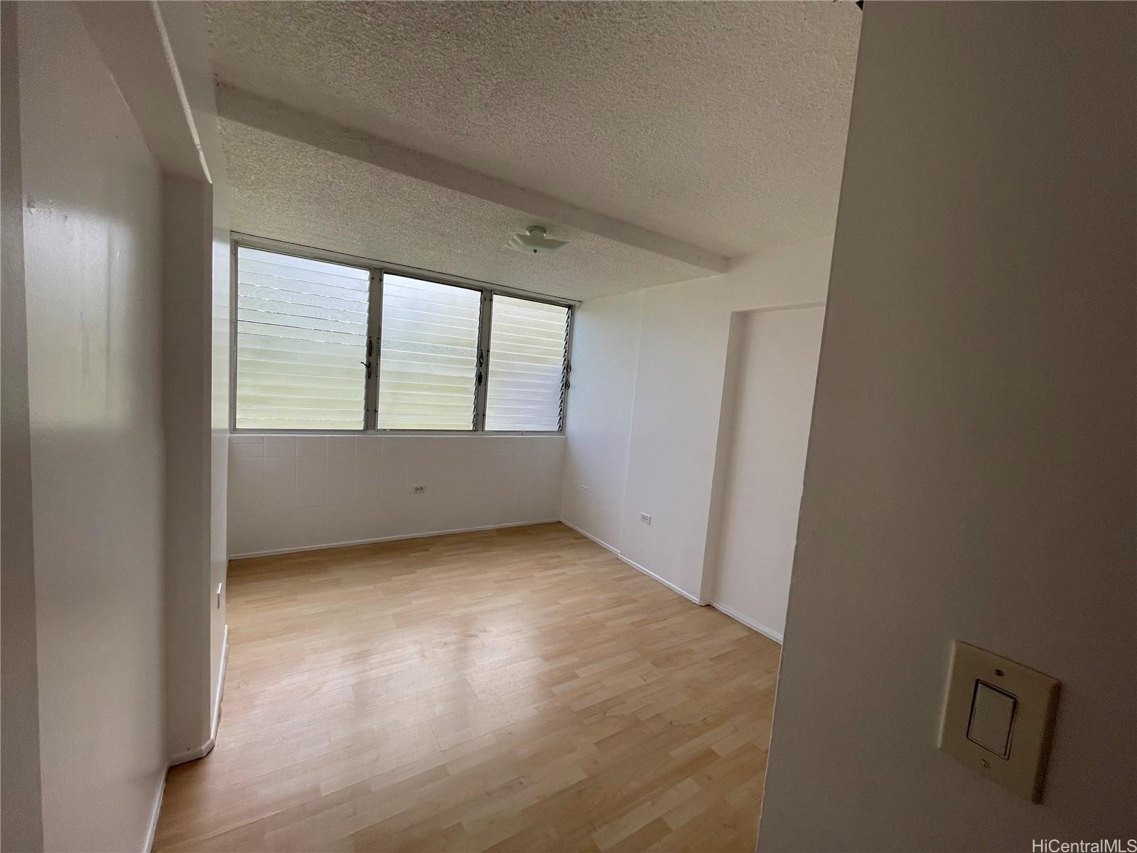 1619 Kamamalu Avenue, Unit 102 Honolulu, HI 96813 - Photo 9 of 18 an empty room with wooden floor and windows