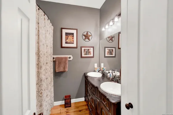 a bathroom with a double vanity sink mirror and tub