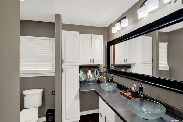 a bathroom with a sink a toilet and a mirror