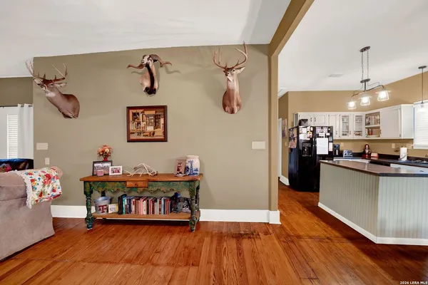 a living room with furniture and kitchen view with wooden floor