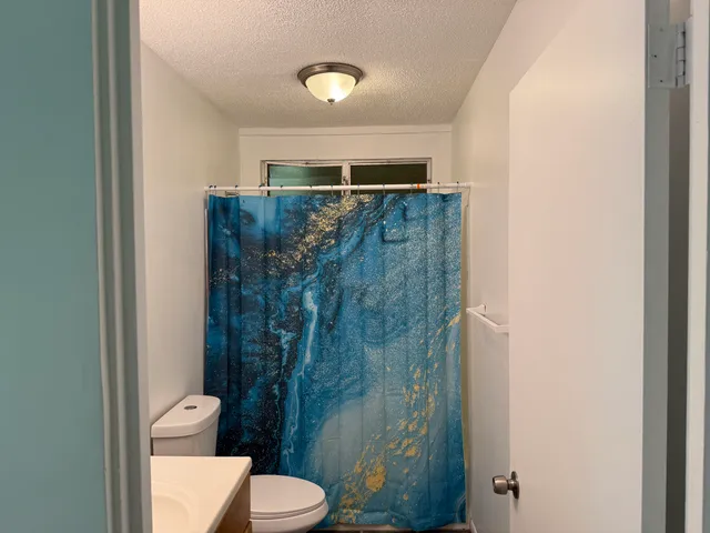 a bathroom with a toilet and a shower