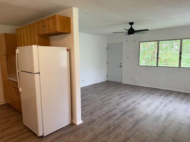 a view of a kitchen with a refrigerator and a ceiling fan