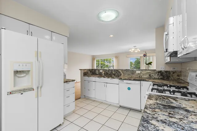 a kitchen with granite countertop a sink and a refrigerator