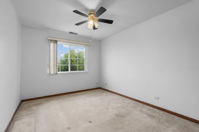 an empty room with a window and a fan