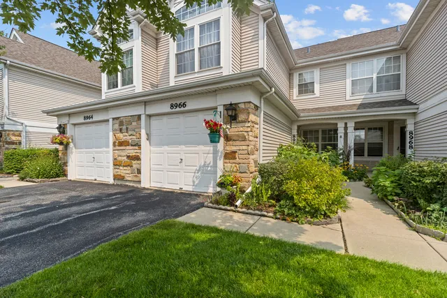 a front view of a house with a garden and yard