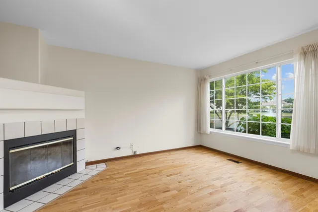 a view of an empty room with a fireplace and a window