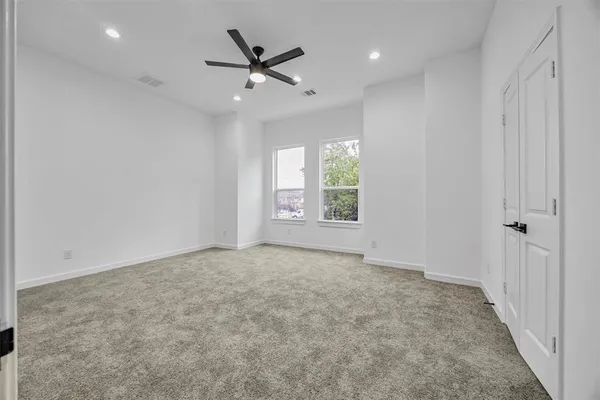 an empty room with windows and fan