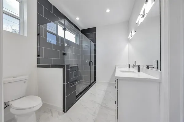 a bathroom with a sink a toilet and shower