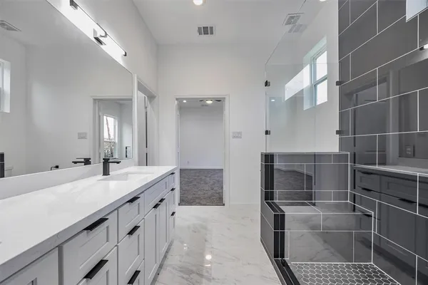 a spacious bathroom with a granite countertop sink a mirror and a shower