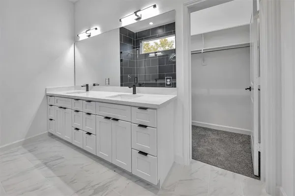 a bathroom with a double vanity sink mirror and shower