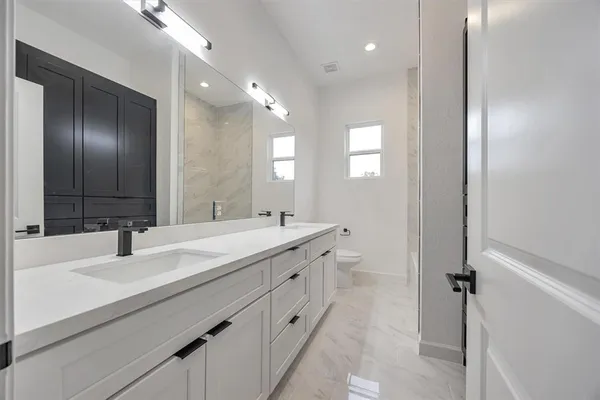 a bathroom with a double vanity sink and a mirror