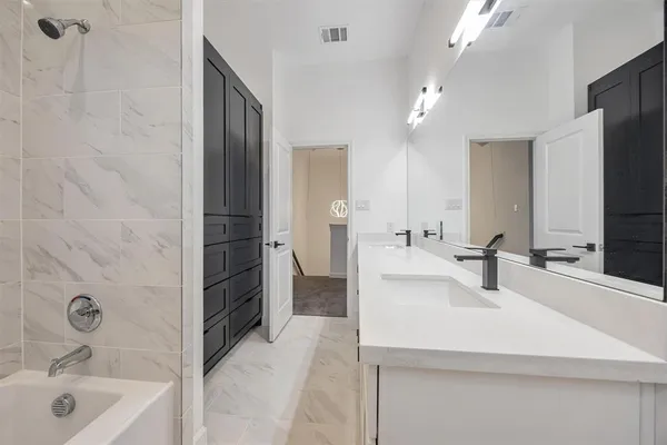 a bathroom with a sink tub vanity and shower
