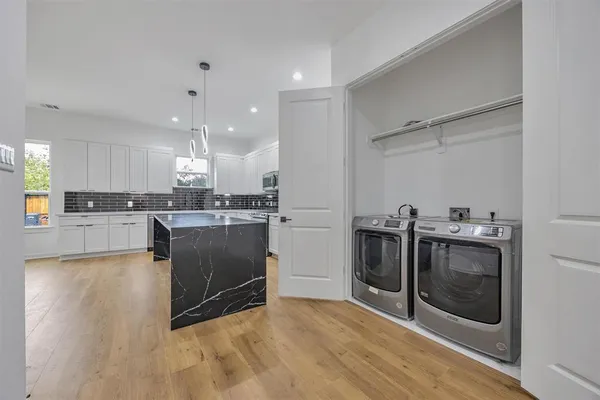 a kitchen with stainless steel appliances kitchen island granite countertop a stove a sink and a refrigerator