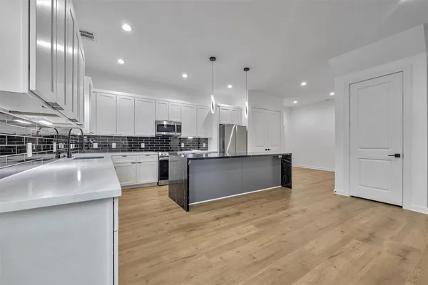 a kitchen with stainless steel appliances granite countertop a sink a stove and a refrigerator