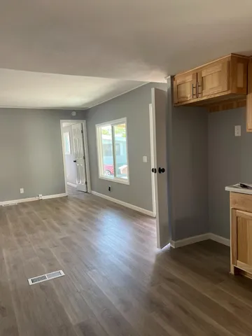 an empty room with wooden floor and a fireplace