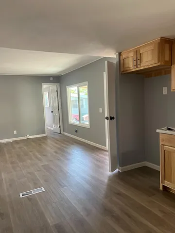 an empty room with wooden floor and a fireplace
