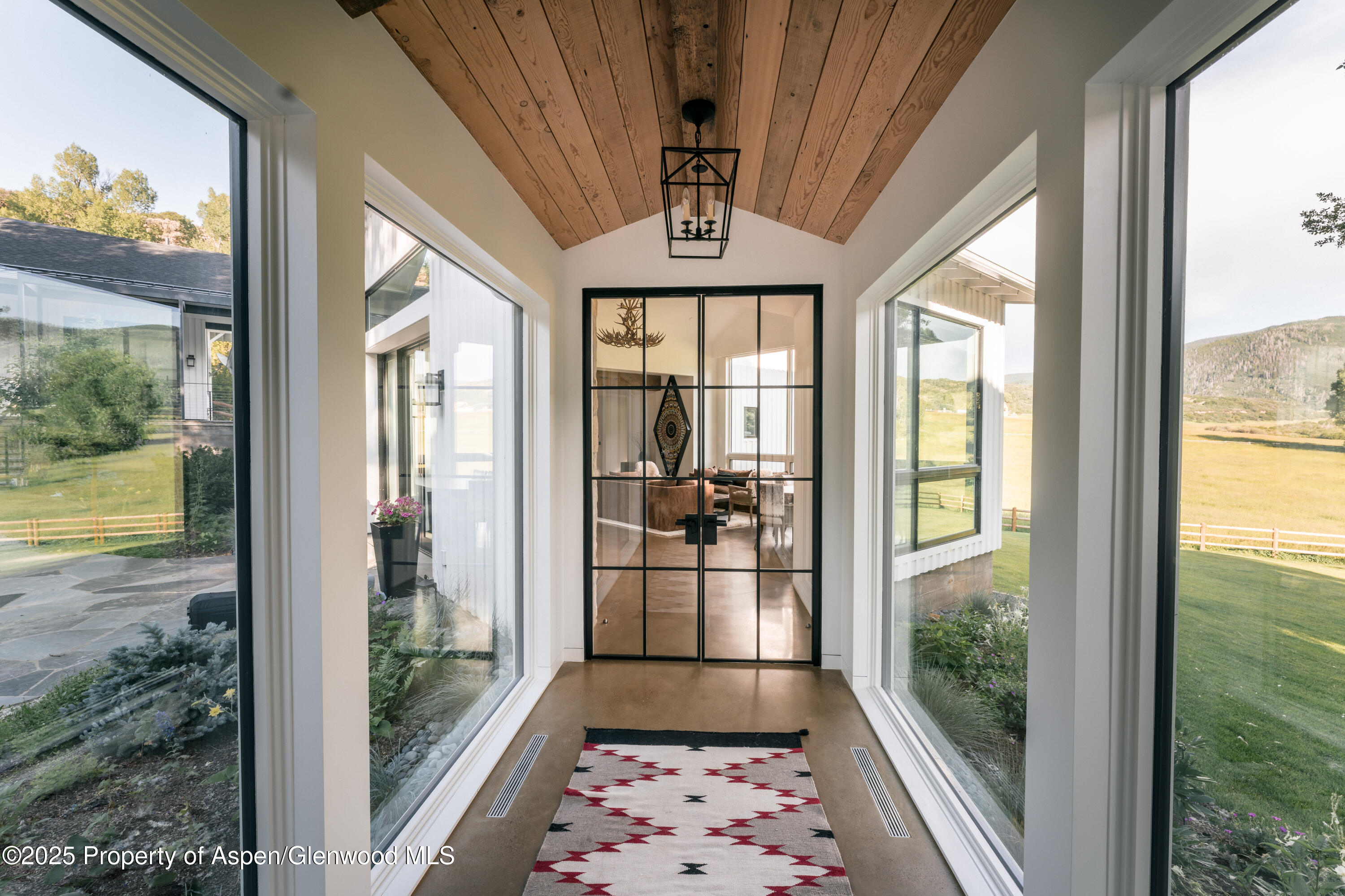 1814 Woody Creek Road Aspen, CO 81612 - Photo 19 of 52 a view of entryway with a floor to ceiling window and wooden floor