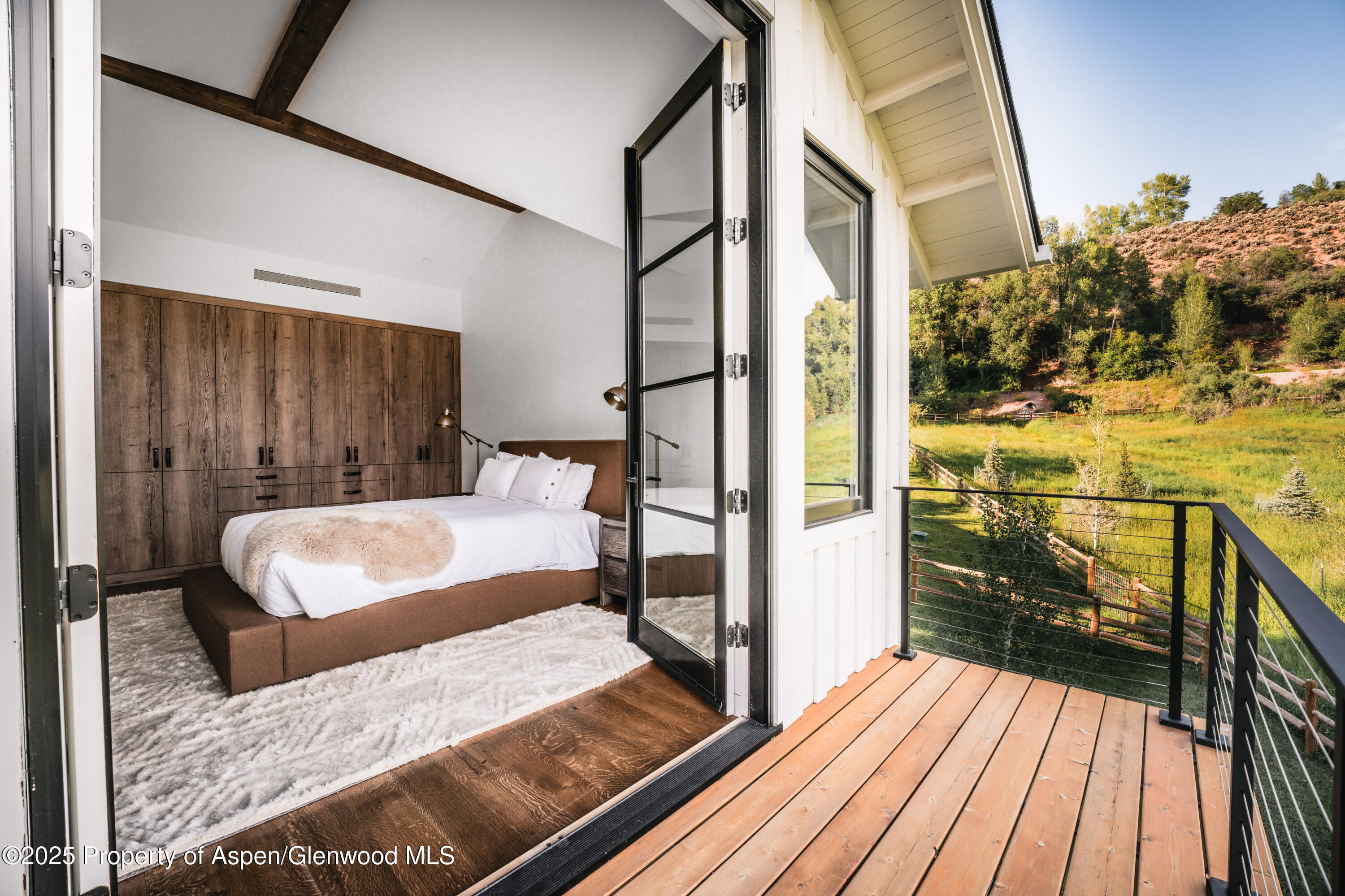 1814 Woody Creek Road Aspen, CO 81612 - Photo 27 of 52 a bedroom with a bed and wooden floor