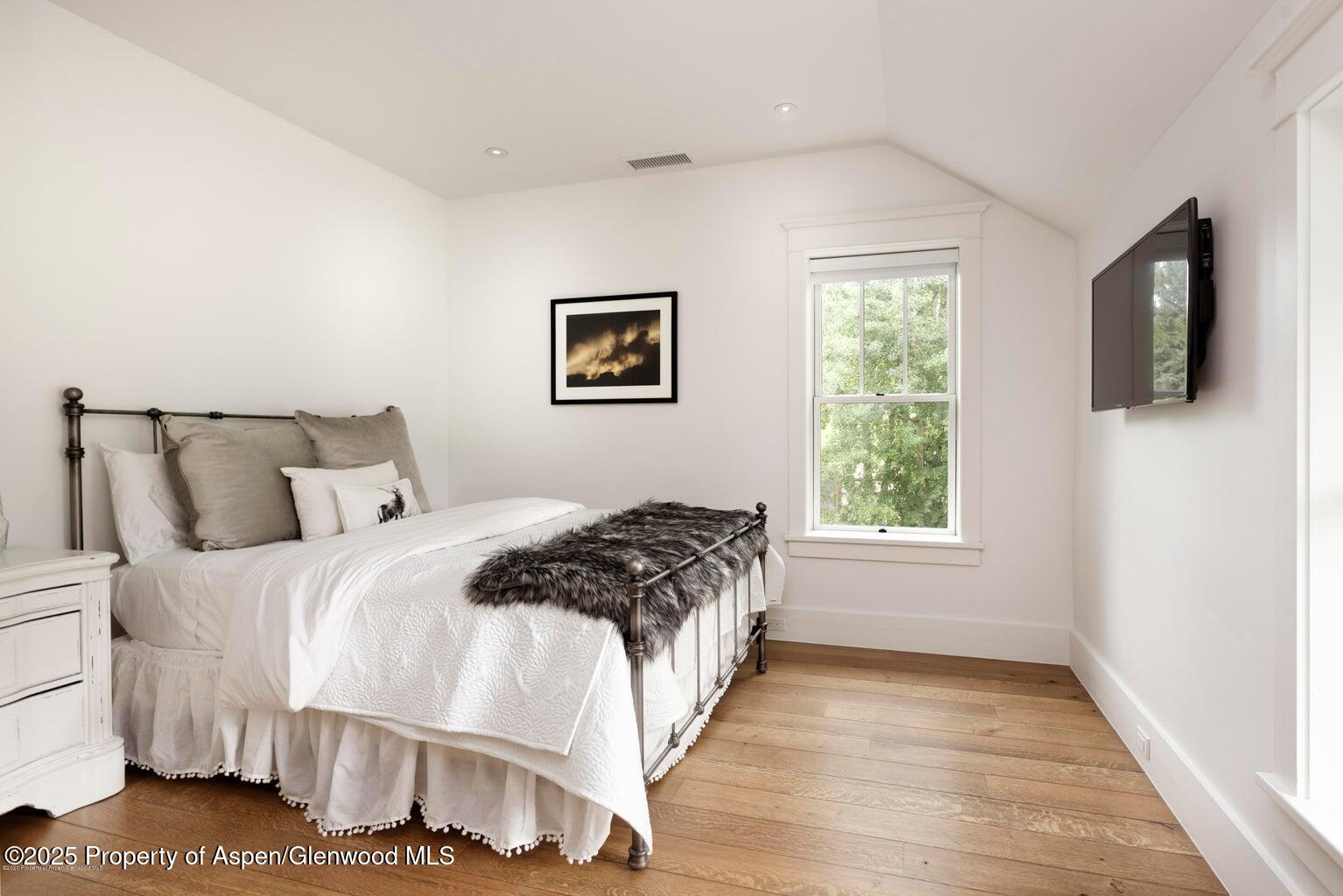 1814 Woody Creek Road Aspen, CO 81612 - Photo 32 of 52 a bedroom with a bed and a flat screen tv