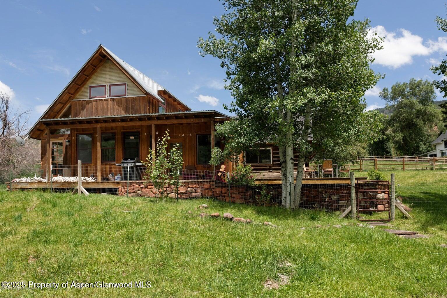1814 Woody Creek Road Aspen, CO 81612 - Photo 46 of 52 a front view of a house with a yard table and chairs