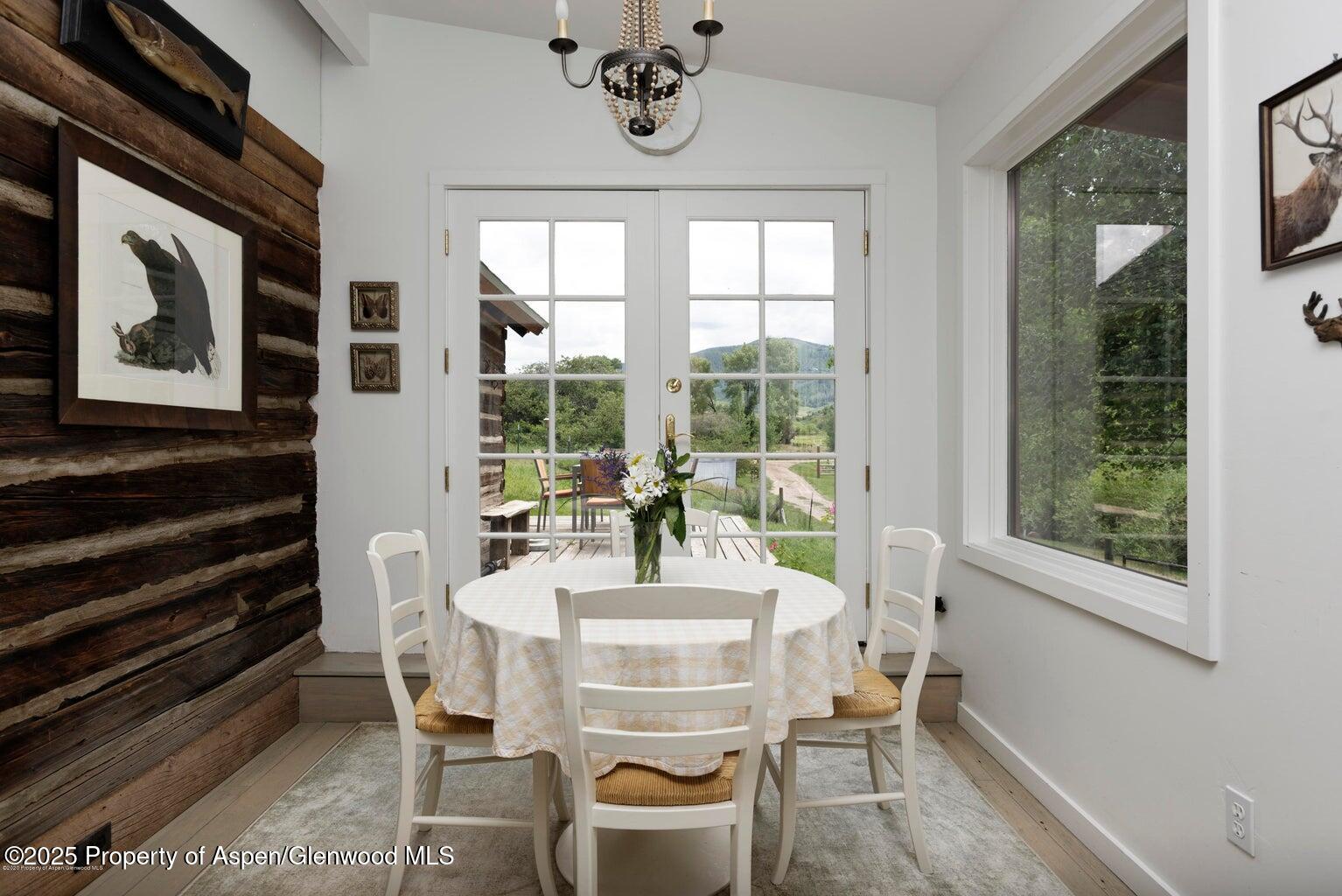 1814 Woody Creek Road Aspen, CO 81612 - Photo 49 of 52 a dining room with furniture large windows and wooden floor