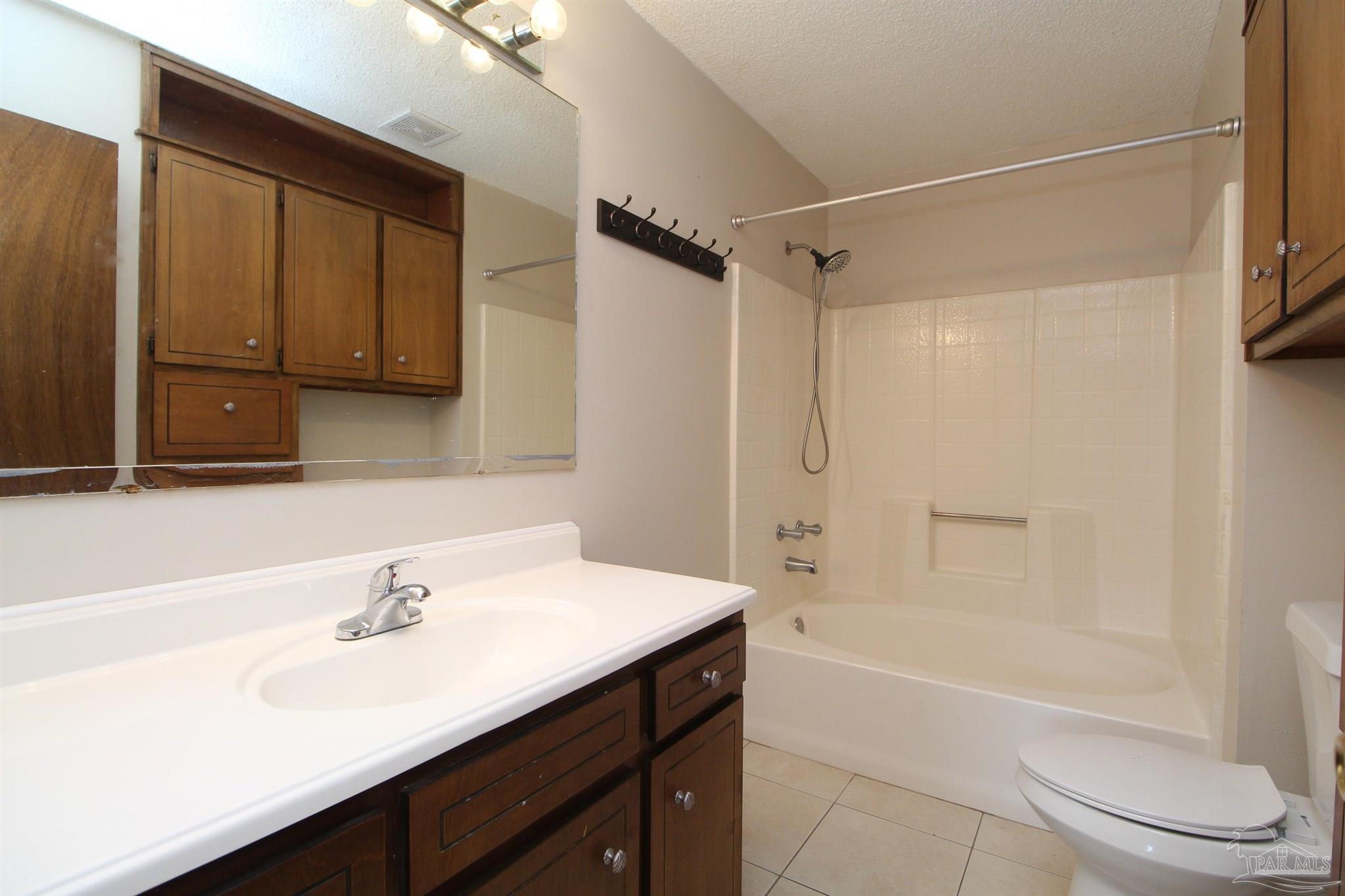 6528 Hunter Street Milton, FL 32570 - Photo 12 of 17 a bathroom with a bathtub shower sink vanity and toilet