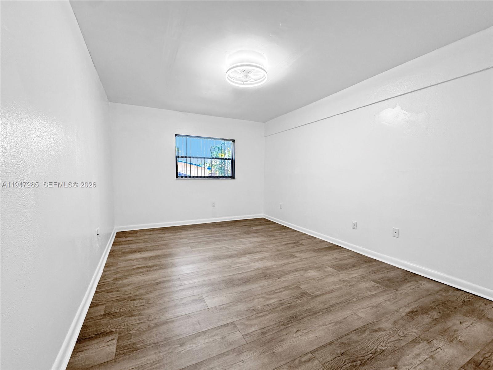 883 Southwest 10th Street, Unit 1 Pompano Beach, FL 33060 - Photo 14 of 20 a view of an empty room with wooden floor