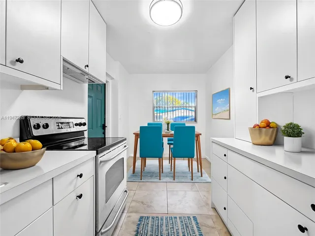 a kitchen with stainless steel appliances a stove a sink cabinets and wooden floor