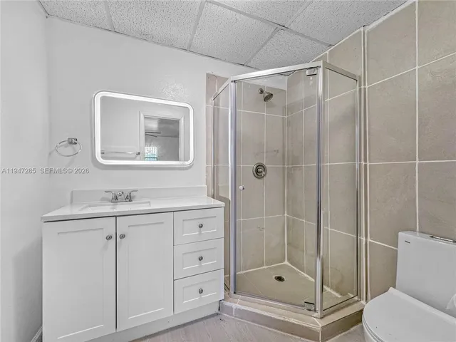a bathroom with a shower a sink a toilet and mirror