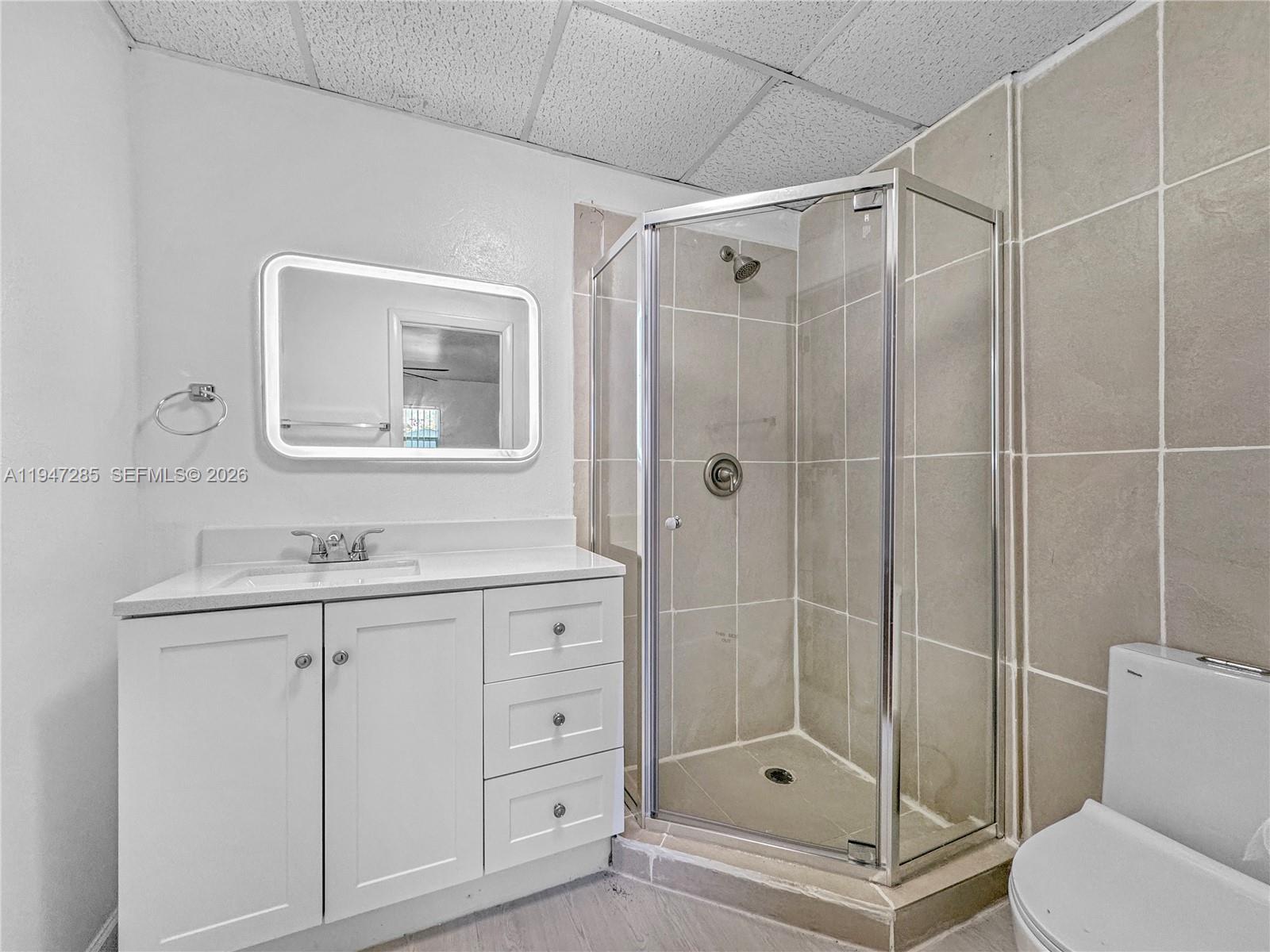 883 Southwest 10th Street, Unit 1 Pompano Beach, FL 33060 - Photo 7 of 20 a bathroom with a shower a sink a toilet and mirror