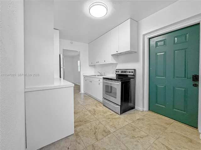 a kitchen with a refrigerator sink and cabinets