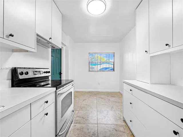 a kitchen with white cabinets and appliances