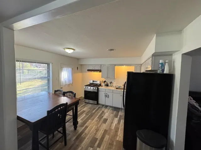 a kitchen with stainless steel appliances a refrigerator a table chairs and a refrigerator