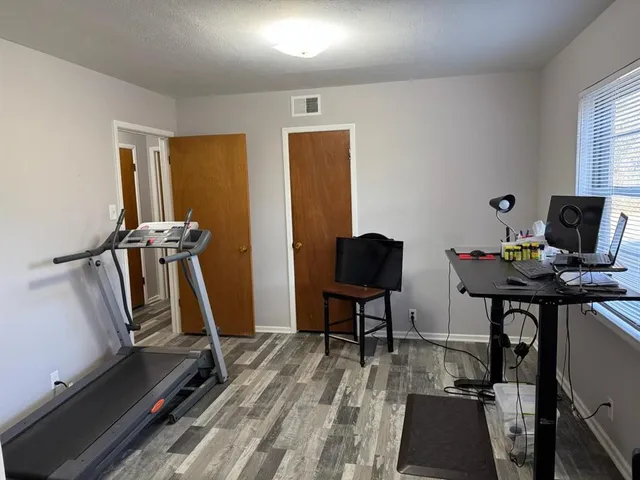 a view of a workspace with furniture and a window