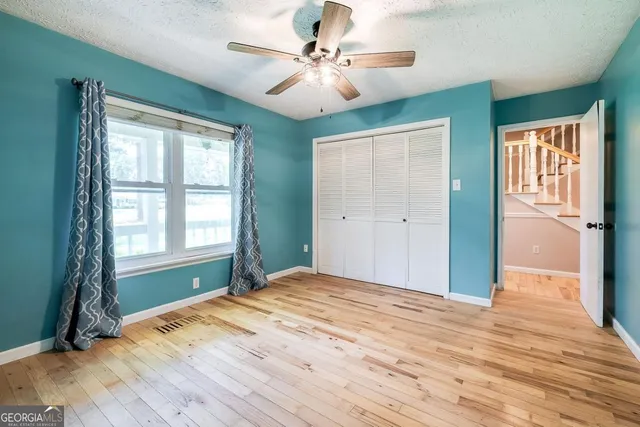 a view of empty room with window and ceiling fan