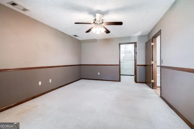 an empty room with closet and windows