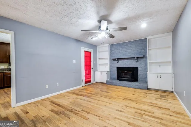 a view of a livingroom with a fireplace and chandelier fan
