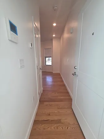 a view of a hallway with wooden floor
