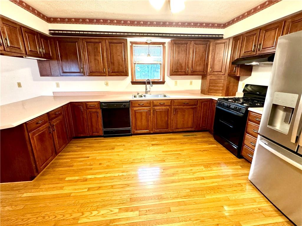 569 Whitestown Road Butler, PA 16001 - Photo 7 of 47 a kitchen with stainless steel appliances granite countertop a stove a sink and a refrigerator