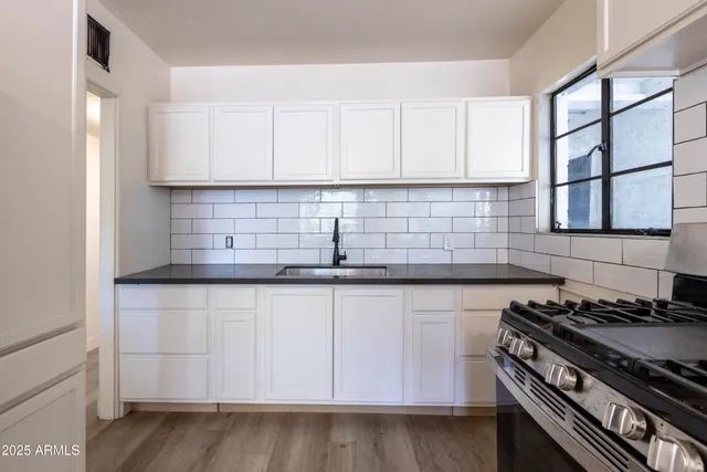 a kitchen with granite countertop a stove and a sink