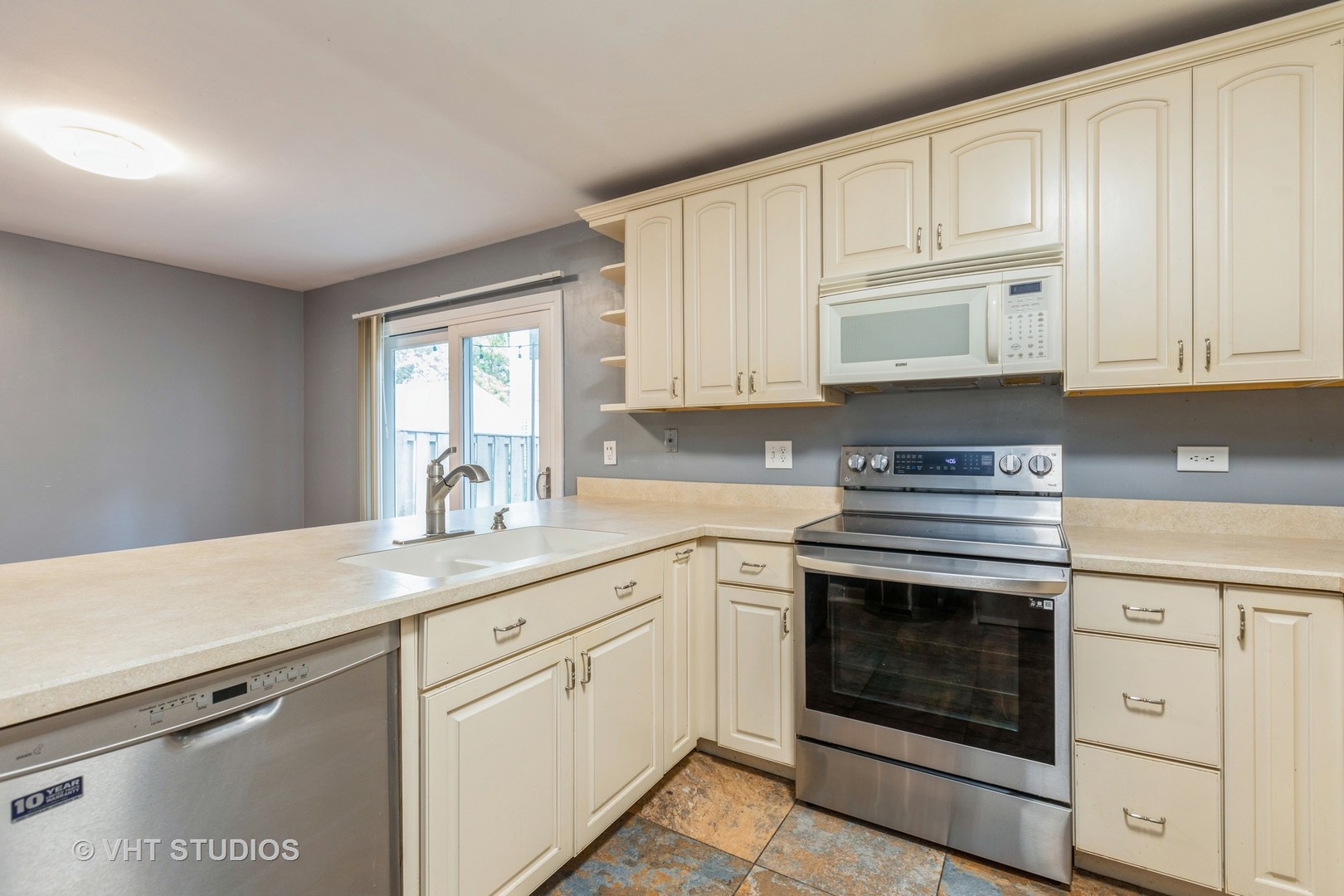 54 Oak Valley Drive Cary, IL 60013 - Photo 6 of 17 a kitchen with cabinets appliances a sink and a window