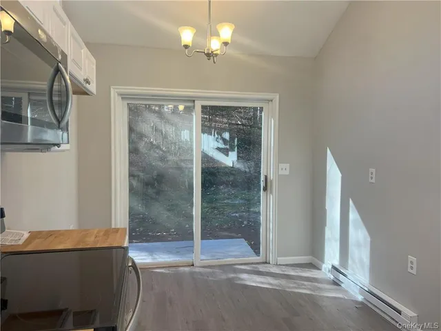 a view of a livingroom with a chandelier fan and windows