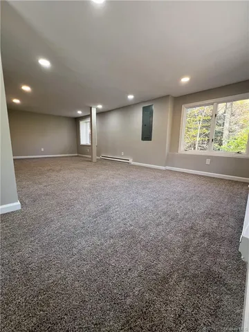 an empty room with windows and refrigerator