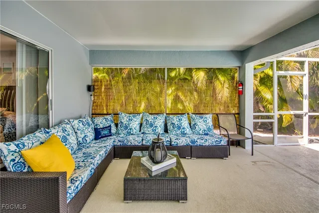 a dining room with furniture large windows and a chandelier