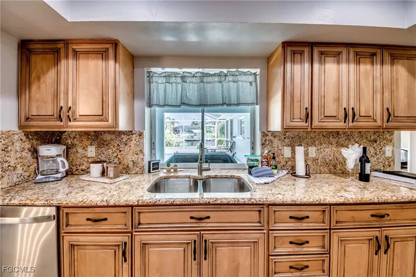 a kitchen with granite countertop white cabinets and a stove top oven with granite countertops