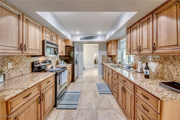 a kitchen with stainless steel appliances granite countertop a stove a sink dishwasher and a refrigerator