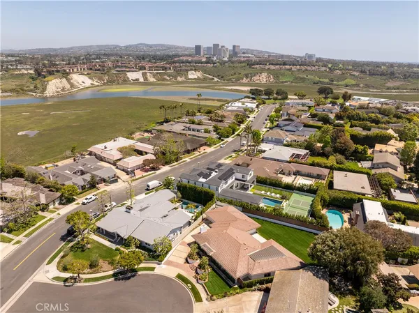 an aerial view of a city with lots of residential buildings ocean and mountain view in back