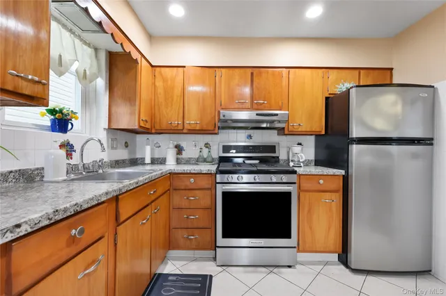 a kitchen with stainless steel appliances granite countertop a refrigerator sink and stove