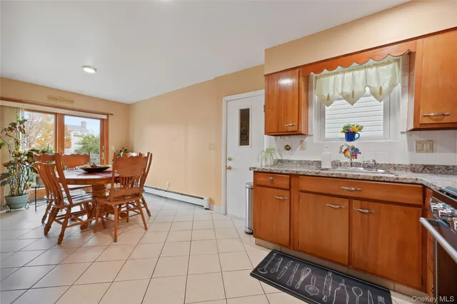 a kitchen with stainless steel appliances granite countertop a table chairs and a refrigerator